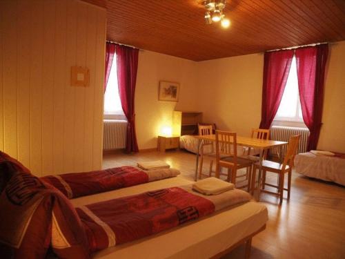 拉诺伊韦维尔加尔尼卡门别墅酒店的一间设有两张床和一张桌子及椅子的房间