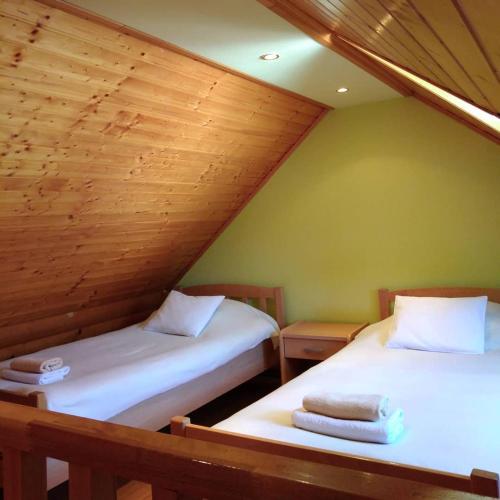 马考巴尔贾Apartment Petra的阁楼间设有两张床铺和木制天花板
