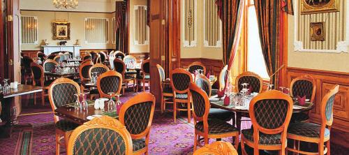 勒威克The Grand Hotel的一间在房间内配有桌椅的餐厅