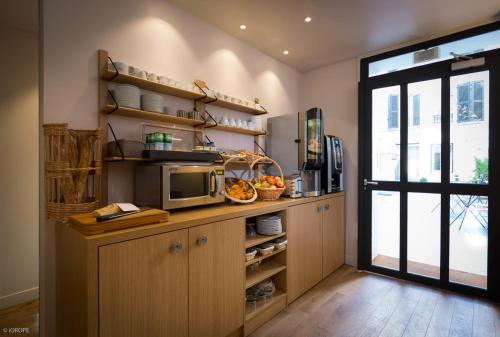 巴黎米拉波艾菲尔酒店的厨房设有微波炉和窗户。