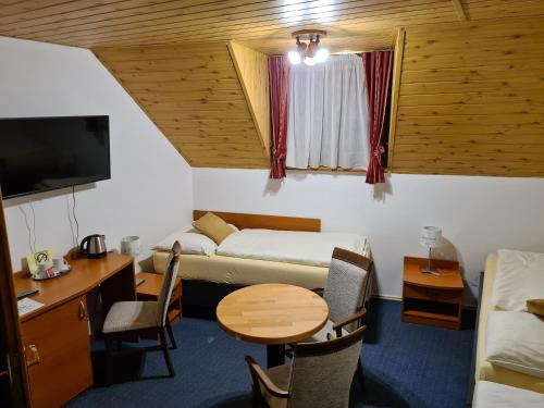 Moldava nad BodvouFerdinand Penzion的客房设有一张床、一张桌子和一张桌子。