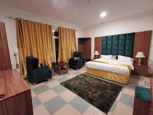 Ash Shuqayqالزمردة للشقق المخدومة的酒店客房,配有一张床和两把椅子
