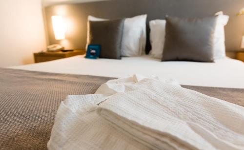 圣安德雷圣安德雷全套房蓝树酒店的一间卧室配有带白色床单和枕头的床。