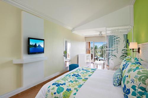 维约堡Coconut Bay Beach Resort & Spa All Inclusive的一间卧室配有一张床,墙上配有电视