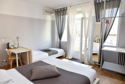 卡普德纳克巴黎咖啡酒店的一间卧室设有两张床、一张桌子和一个窗口