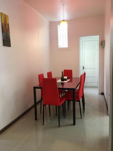 维纳德马CasaAmarilla Viña del Mar的一间用餐室,配有红色的椅子和桌子