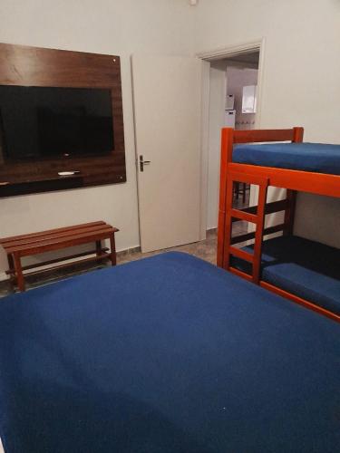 奥林匹亚Casa em Olímpia的客房设有一张床和一台平面电视。