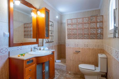 哈维亚Villa Suria的一间带水槽、卫生间和镜子的浴室