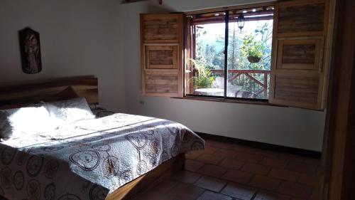 麦德林La Casona Del Retiro的一间卧室设有一张床和一个窗口