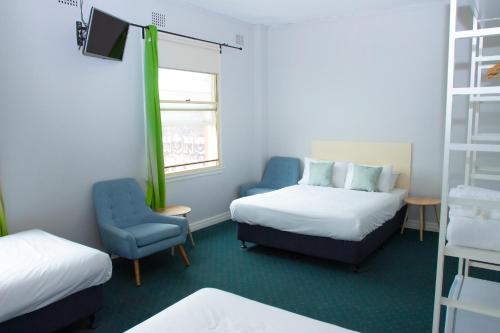 悉尼罗克代尔格兰德酒店的小房间设有两张床和椅子