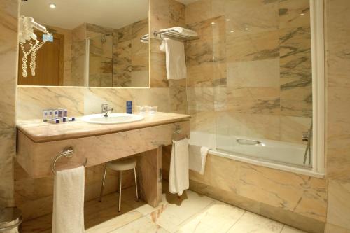 莱加内斯南方公园酒店的浴室配有盥洗盆和浴缸。