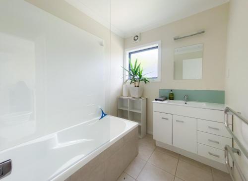 哈威亚湖Stunning Panoramic Lake Hawea Views 5 Bedrooms的白色的浴室设有浴缸和水槽。