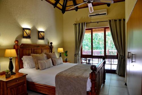 雾观Cambalala - Luxury Units - in Kruger Park Lodge - Serviced Daily, Free Wi-Fi的一间卧室设有一张床和一个大窗户