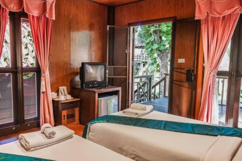 Bān Tha Pu Deang班维南野营度假村的配有电视和阳台的客房内的两张床