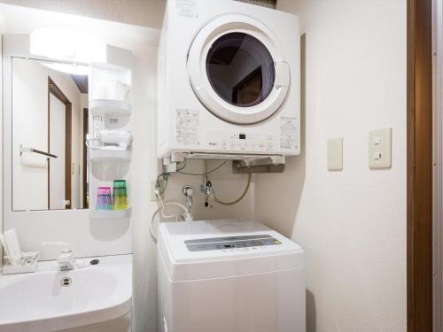那霸Ryujin Hotel Ukishima的一间带洗衣机和水槽的浴室