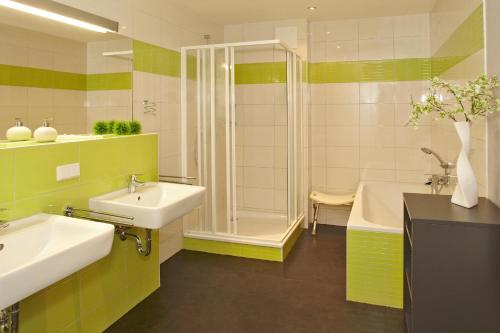 施托尔佩奥夫乌塞多姆Der Landhof Strandhafer的浴室配有2个盥洗盆、淋浴和浴缸。