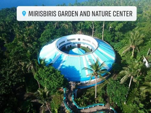 Santo DomingoMirisbiris Garden and Nature Center的森林中间的蓝色建筑