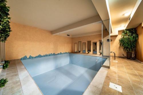 沃迪切Hotel Nikola的一座大型游泳池,位于一座铺有瓷砖地板的建筑内