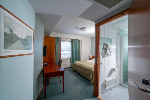 哈米纳哈米纳水疗酒店的酒店客房设有一张床、一张书桌和一间浴室。