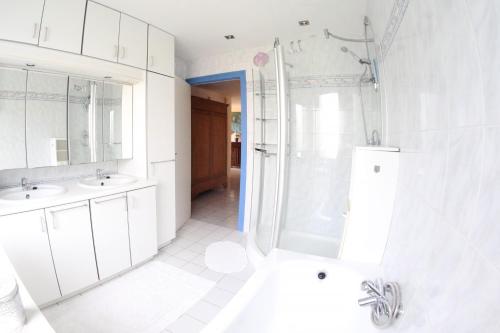 文代讷Westhinder的白色的浴室设有2个盥洗盆和淋浴。