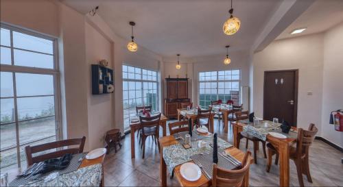 努沃勒埃利耶Misthill Rest - Lavish Villa的用餐室设有桌椅和窗户。
