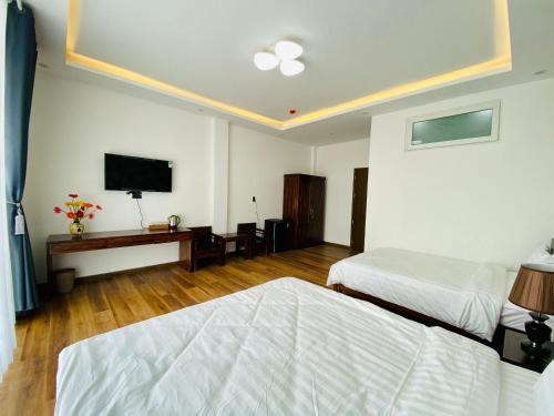 大叻Mỹ Lan hotel的一间卧室配有两张床和一台平面电视