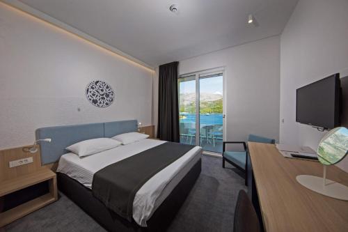 斯拉诺Hotel Osmine的酒店客房配有一张床、一张书桌和一台电视。