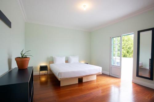 蓬塔德尔加达Salt Lips Surf & Coworking Azores的白色的卧室设有床和窗户