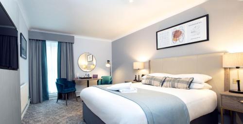 北安普敦塞奇布鲁克庄园酒店的酒店客房设有一张大床和一张书桌。