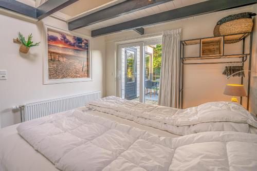 德科赫Zee van Tijd的窗户客房内的一张大白色床
