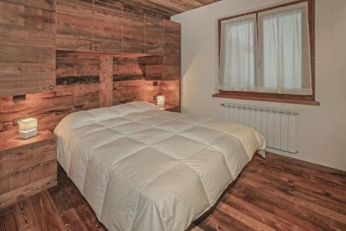 萨奥兹-杜尔克斯Snowflake Appartamenti Jouvenceaux的一间卧室设有一张床和木墙