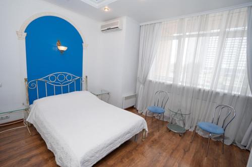 基辅Hotel Piano的一间卧室配有一张床和两张蓝色椅子