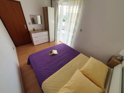 克尔克Apartmani Alta的一间卧室配有一张紫色床,上面装有盒子