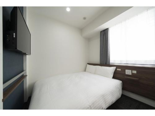 仙台R&B Hotel Sendai Higashiguchi - Vacation STAY 14656v的卧室配有白色的床和窗户。