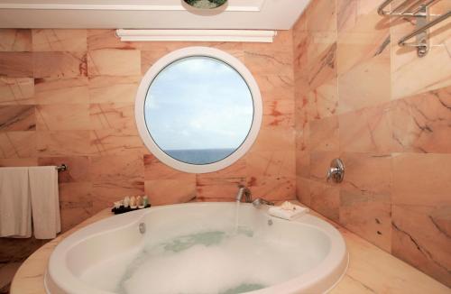 米乔尔海滩福门特拉海滩因索特尔酒店的带浴缸的浴室和圆形窗户。