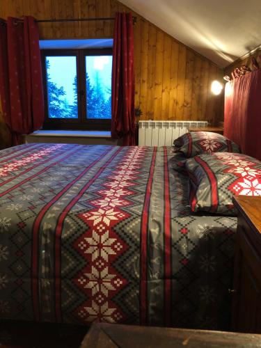 切萨纳·都灵尼斯Rifugio Baita Gimont的一间卧室设有两张床,其中设有窗户。