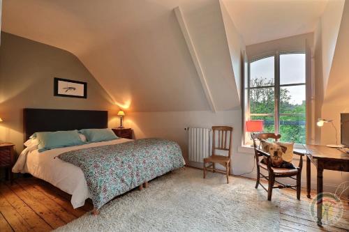 Le Minihic-sur-RanceLa Maison Les Mimosas的一间卧室配有一张床、一张书桌和一个窗户。