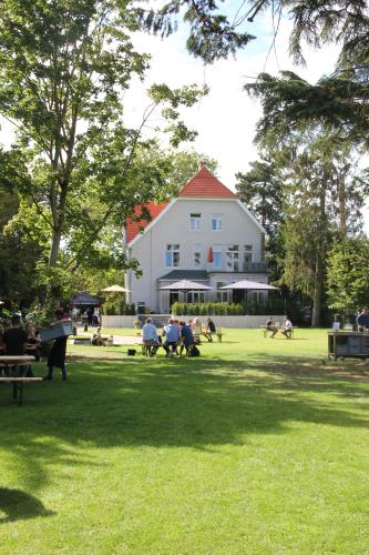 海因斯贝格Villa Glanzstoff的一群人坐在公园的草地上