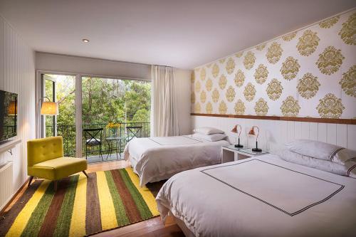 萨帕利亚尔卡萨萨帕拉尔酒店的一间卧室配有两张床和一张黄色椅子