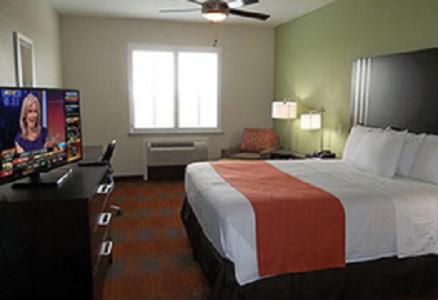 维多利亚Quality Inn & Suites Victoria East的配有一张床和一台平面电视的酒店客房