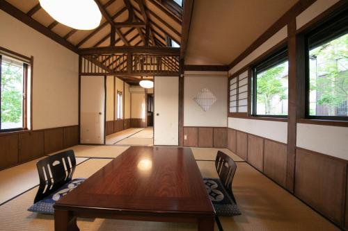 由布市由布院温泉冨季日式旅馆的一间带木桌和椅子的用餐室