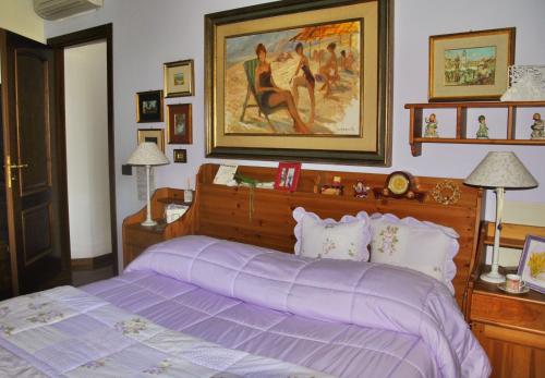 卡斯泰尔夫兰科埃米利亚马切罗堂乡村民宿的一间卧室配有一张紫色的床,墙上挂着一张照片