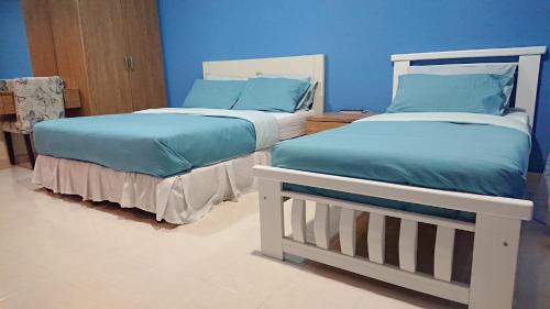 哥打巴鲁AlRayani Guest Room, Homestay Kota bharu的两张睡床彼此相邻,位于一个房间里