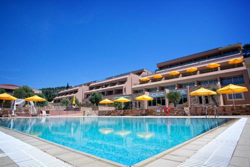 波托什皇家天堂海滩度假酒店及水疗中心的一座带黄色遮阳伞的游泳池和一座建筑