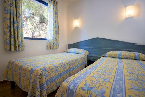 米乔尔海滩Insotel Club Maryland的配有窗户的酒店客房内的两张床