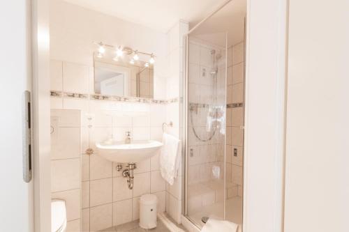 GroßenlüderHotel- Restaurant Zum Hirsch的白色的浴室设有水槽和淋浴。
