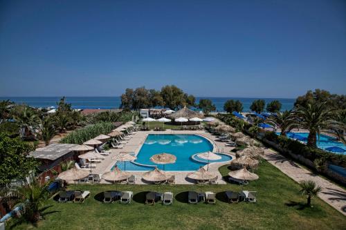 普拉坦斯黄金酒店的享有带游泳池和遮阳伞的度假村的空中景致