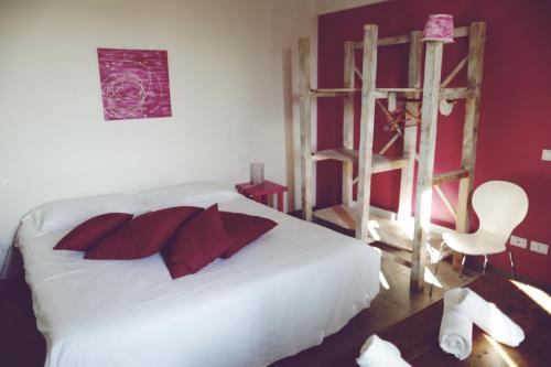 Marmirolo阿格里图瑞斯木比亚提拉酒店的卧室配有白色的床、红色枕头和梯子
