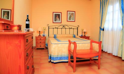 卡勒达德福斯特卡勒塔多拉达VIP别墅酒店的一间卧室配有一张床、一把椅子和一个梳妆台