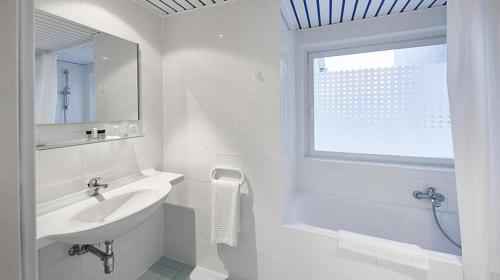 卢森堡法国酒店的白色的浴室设有水槽和窗户。